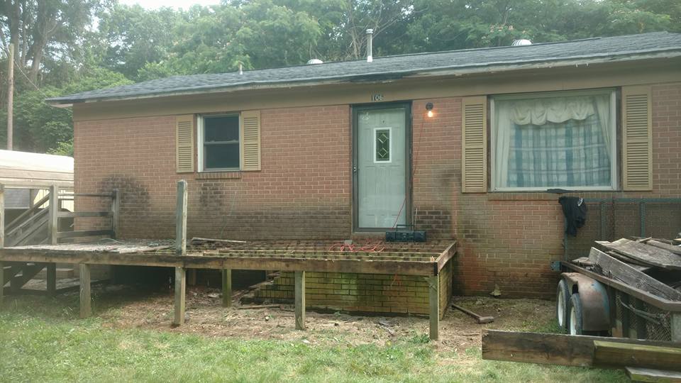 Old deck, stained brick, loose shutters.