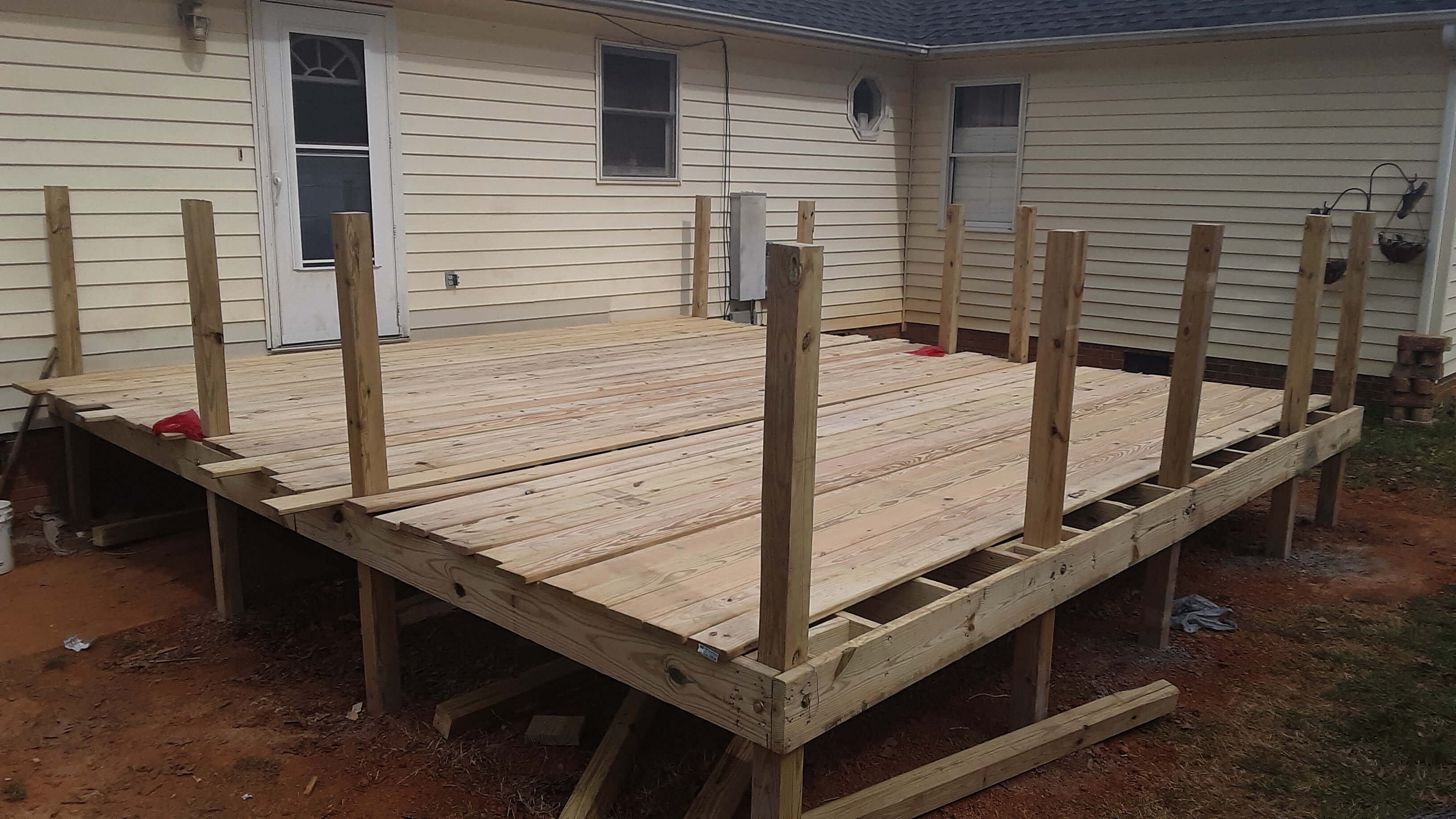 A wooden deck in the early stages of a rebuild.